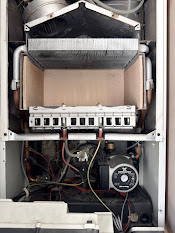 Open gas boiler showing heat exchanger and burner during an annual service