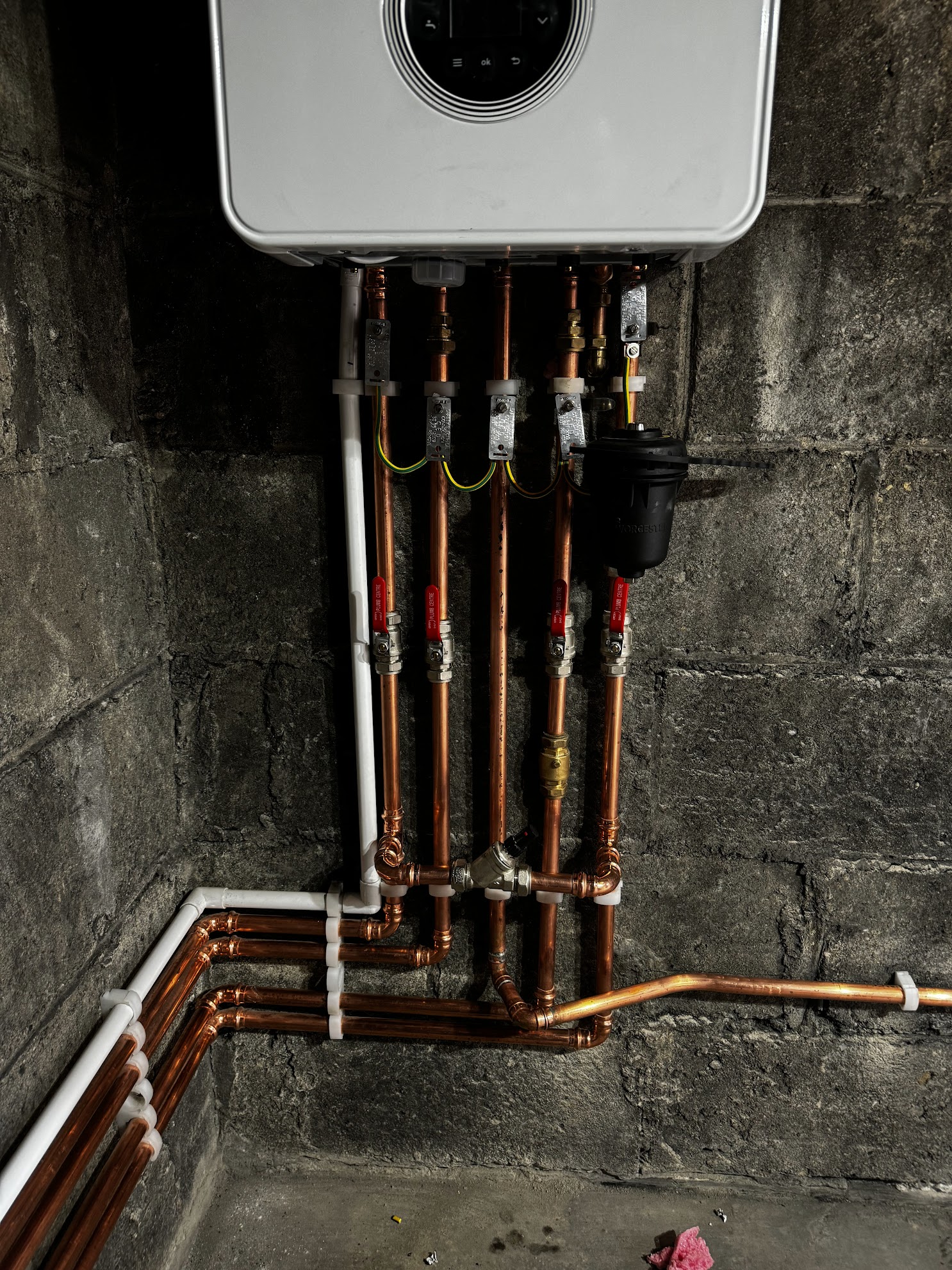 Neatly clipped copper pipework beneath a newly installed gas boiler